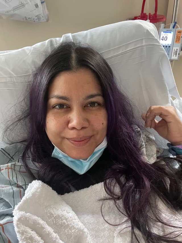 A woman laying in a hospital bed with a cast on her neck